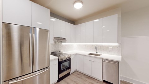 a kitchen with white cabinets and stainless steel appliances